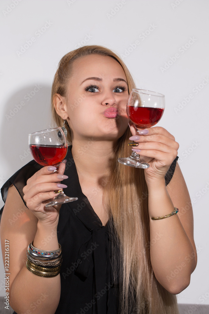 A woman is holding two wine glasses and making a funny face