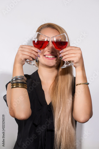 A woman is holding two wine glasses and smiling