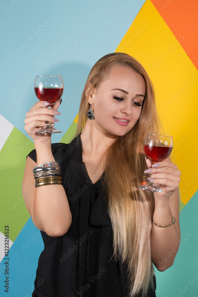 A woman is holding two wine glasses and smiling