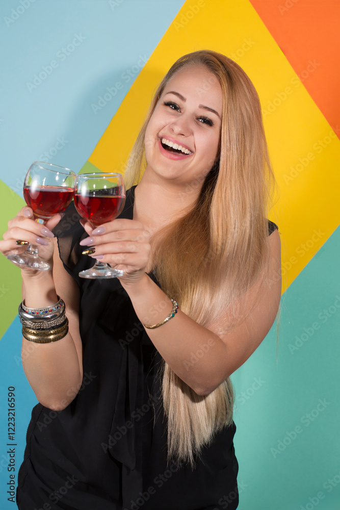 Cheerful blonde woman holding two glasses of red wine and smiling. Holiday concept Cheerful blonde woman holding two glasses of red wine and smiling. Holiday concept