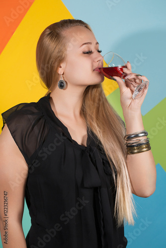 Obraz na płótnie Cheerful blonde woman holding two glasses of red wine and smiling w salonie