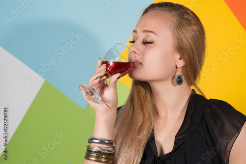 Obraz na płótnie A blonde woman holding two glasses of red wine and smiling w salonie