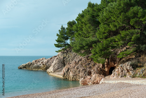 Rocky Mediterranean Shoreline with Pine Trees, Pebble Beach, a Hidden Coastal Cave, and Azure Blue Sea
