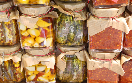 Garlic peppers and fish in glass jars under oil packaged in the Italian country