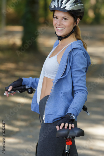 toned female cyclist wearing vest and protective helmet photo