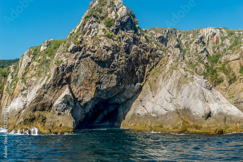 Rocky mountain by the sea with a cave in the middle, located in the Cabo Frio region, Rio de Janeiro, Brazil. photo