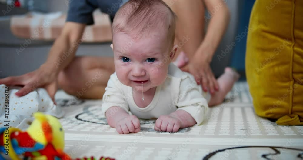 Baby spends tummy time on a mat at home, strengthening muscles and coordination Baby spends tummy time on a mat at home, strengthening muscles and coordination