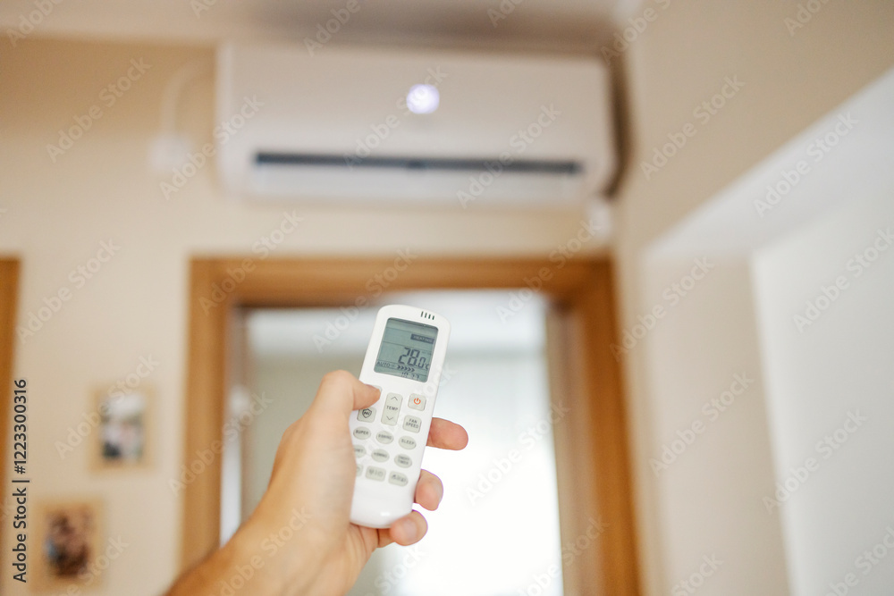 Close up of hand holding remote control and increasing temperature of air conditioner. Close up of hand holding remote control and increasing temperature of air conditioner.