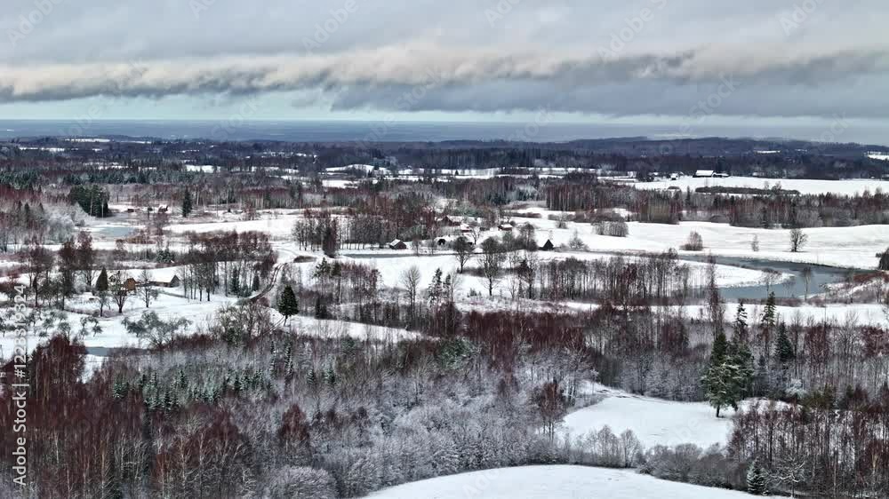 Drone flyby shot over snow covered field with thick clouds in sky. Day view. Drone flyby shot over snow covered field with thick clouds in sky. Day view.