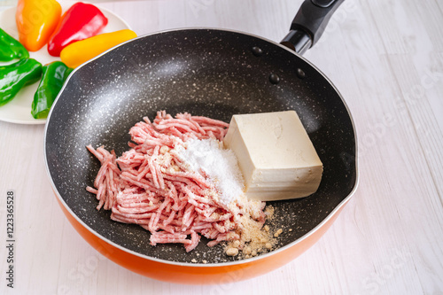 フライパンに入れた挽肉と豆腐と調味料 photo