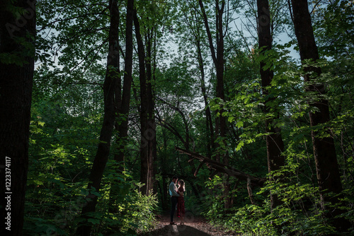 Silhouettes of a couple in love standing opposite each other, against the backdrop of the forest, night, love, love story, Valentine's Day.