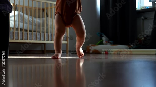 A toddler takes his first steps in a cozy home setting, filled with warmth and excitement. A heartwarming moment of growth and achievement.