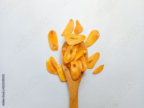 Fried garlic chips or slice on wooden spoon. Use as condiment topping in various Indonesian culinary meal.