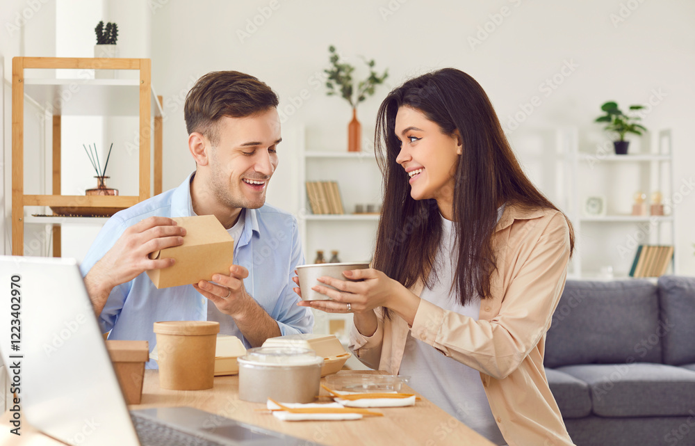 Portrait of happy couple enjoying delicious food delivered in eco-friendly packaging. Couple at home excitedly opens food containers. Advertising concept for modern food delivery and takeaway services Portrait of happy couple enjoying delicious food delivered in eco-friendly packaging. Couple at home excitedly opens food containers. Advertising concept for modern food delivery and takeaway services