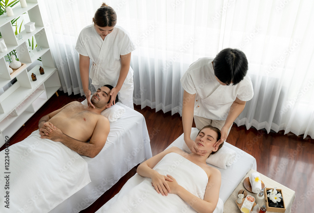 Obraz premium Caucasian couple enjoying relaxing anti-stress head massage and pampering facial beauty skin recreation leisure in dayspa modern light ambient at luxury resort or hotel spa salon. Quiescent