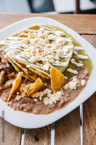 Plato de chilaquiles verdes con frijoles refritos photo