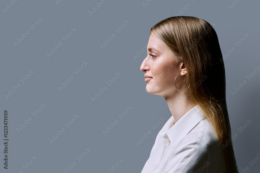 Profile view, confident young woman, copy space gray studio background Profile view, confident young woman, copy space gray studio background