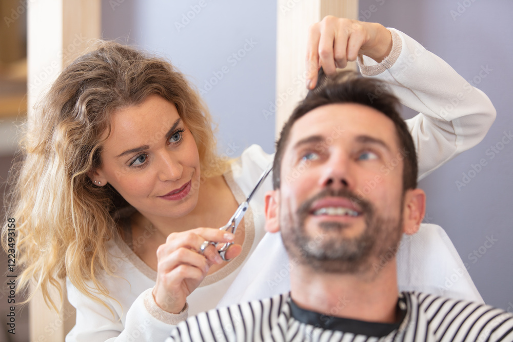 Fototapeta premium close-up female hairdresser cutting hair of man client