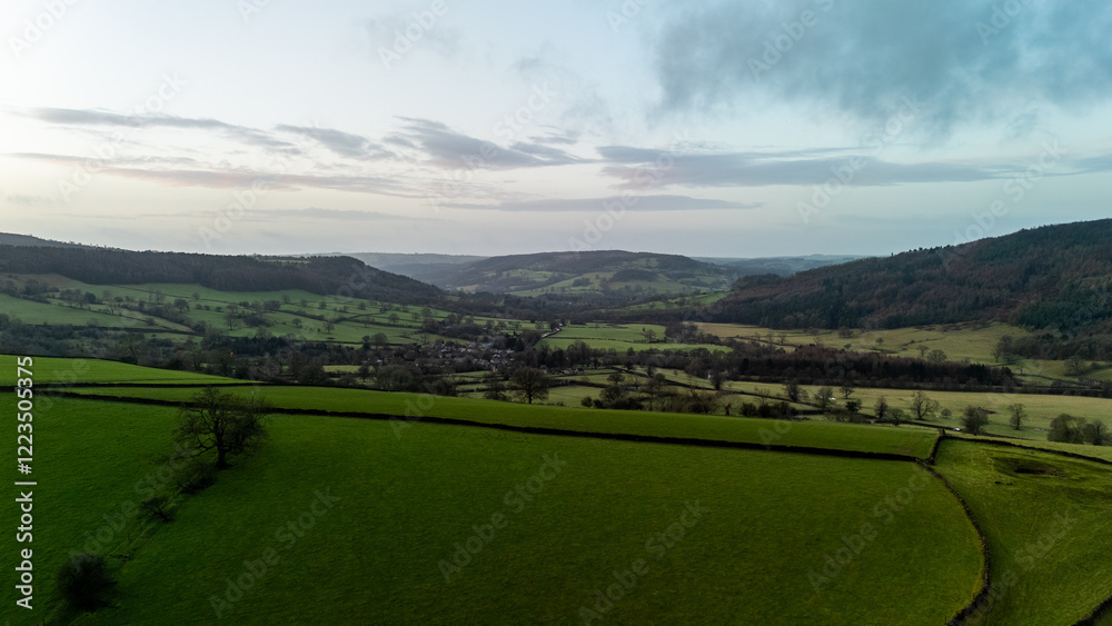 Obraz premium Stunning aerial view of green valley with fields and hills at sunset in the English countryside