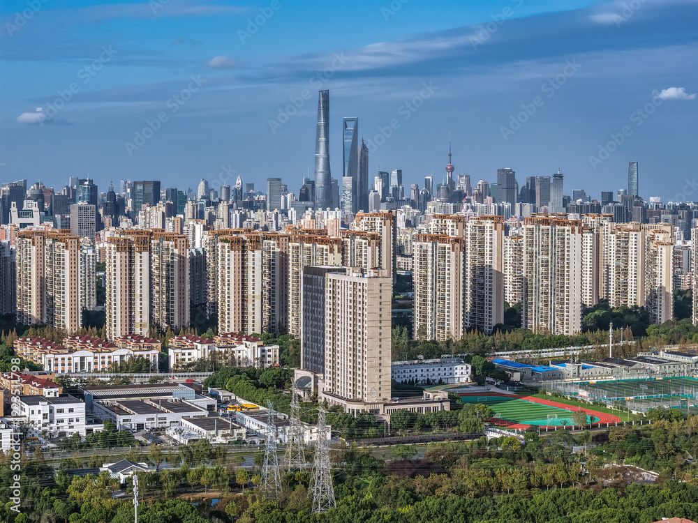 Obraz premium The drone aerial view of residential district in Pudong with skyscrapers in the background, Shanghai, China. 