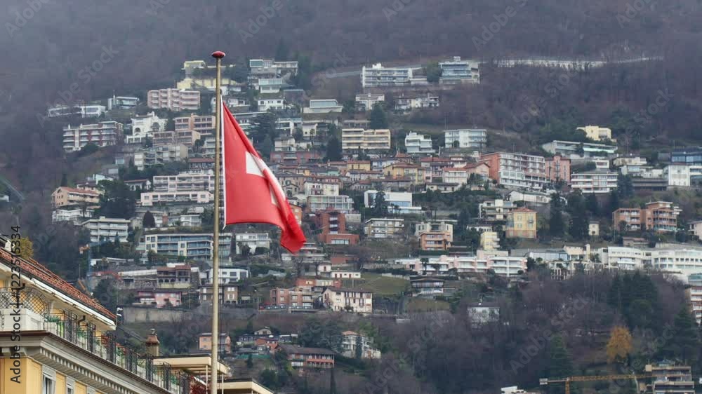 Swiss flag waving with Monte Bre in the background, Lugano, Switzerland