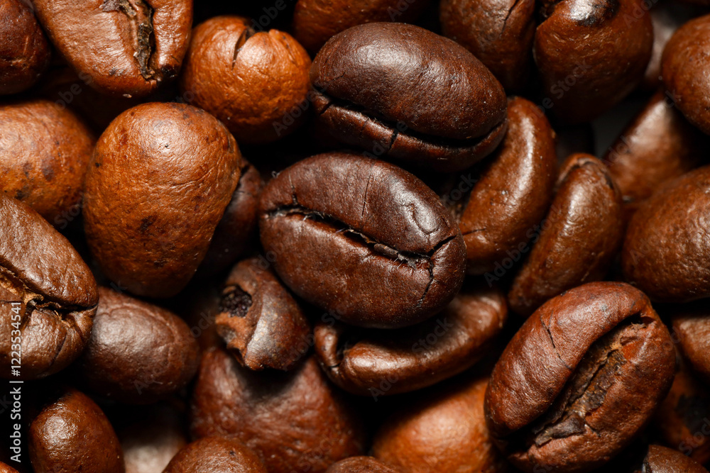 Naklejka premium A macro close-up of roasted coffee beans showcasing their rich brown color, detailed texture, and natural oils. The beans are tightly packed, emphasizing their unique shapes and surface patterns.