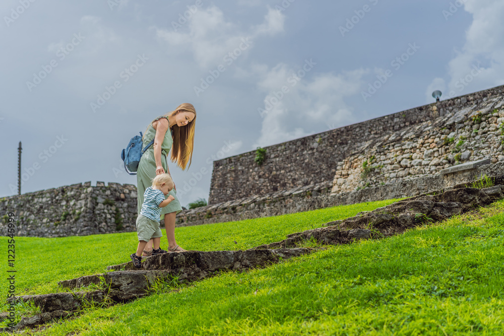 Mother with her toddler and teenage sons exploring Fuerte de San Felipe de Bacalar. Family travel, cultural heritage, and historical adventure concept