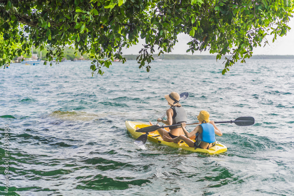Mother and son tourists kayaking on Bacalar Lake in Mexico. Adventure tourism in Quintana Roo, outdoor exploration, and water activities concept