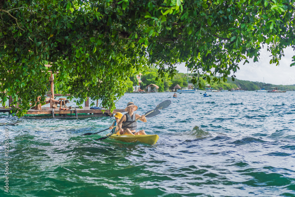 Mother and son tourists kayaking on Bacalar Lake in Mexico. Adventure tourism in Quintana Roo, outdoor exploration, and water activities concept