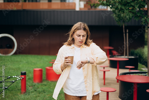 Frustrated and angry young woman, who waiting for a friend who late for an appointment. Urban lifestyle concept. Why are you late concept. I am waiting here for hours. photo