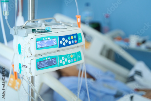 Hospital feeding pump by hospital  bed with female patient on background after colon cancer surgery