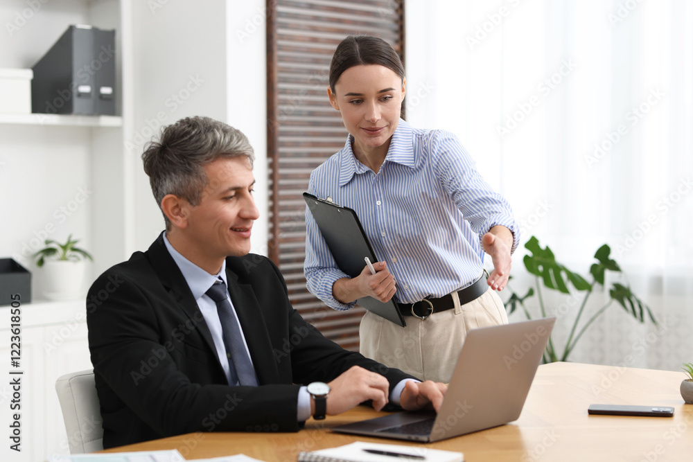 Coworkers with laptop working together in office Coworkers with laptop working together in office