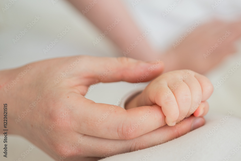 Happy family. Tiny newborn infant baby little hand on mother hand palm. Newborn baby holding parent finger after birth. Mom baby at home. Support protection of new life. Handle with care Happy family. Tiny newborn infant baby little hand on mother hand palm. Newborn baby holding parent finger after birth. Mom baby at home. Support protection of new life. Handle with care