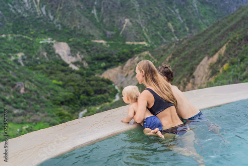 Obraz na płótnie Mother with her toddler and teenage sons bathing in the hot springs of Grutas Tolantongo, Mexico. Family adventure, relaxation, and natural wellness concept w salonie