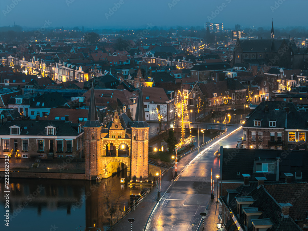 Naklejka premium Night aerial of historic Frisian city Sneek with iconic Watergate and traditional skutsje ship