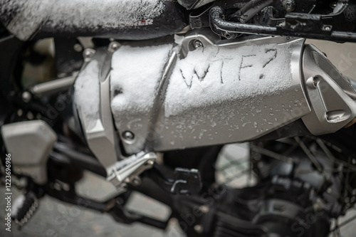 A large black touring motorcycle is covered in snow. The end of the motorcycle season, winter. The inscriptions 