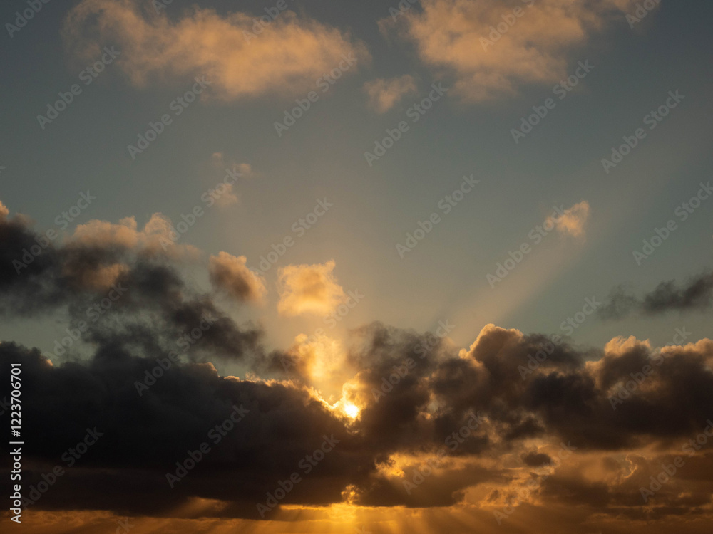Dark dramatic sunset sky with clouds and sun beams and flare. Nature background for design and sky replacement. Dark dramatic sunset sky with clouds and sun beams and flare. Nature background for design and sky replacement.