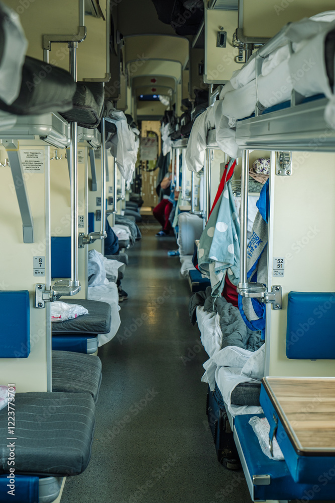 Fototapeta premium Passengers are relaxing on a third class carriage of a russian train, enjoying the journey and the passing landscapes