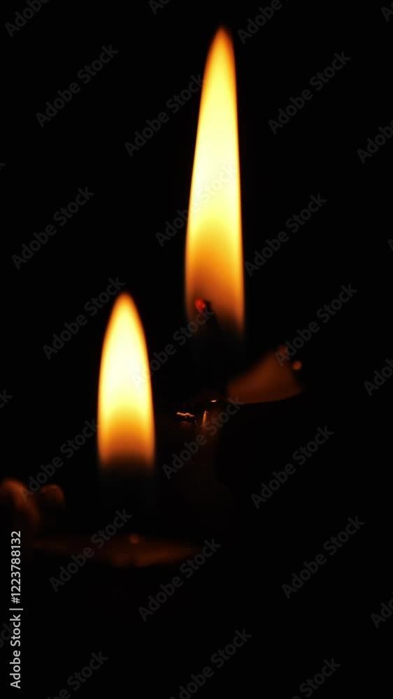 Burning black candles on a black background.Vertical video. Magic and esotericism. Flame of black candles in the dark. Atmospheric magic. 4k footage
