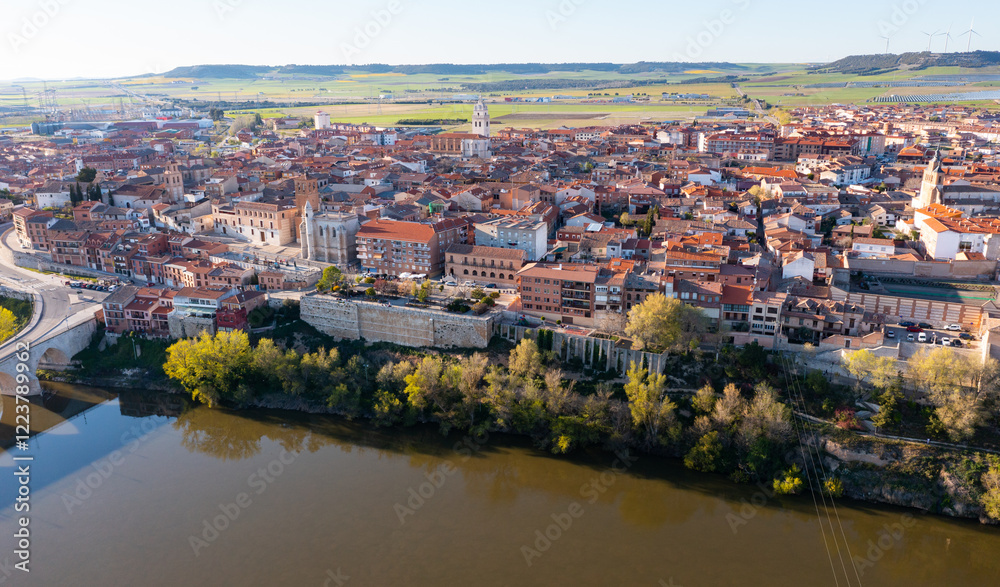 Fototapeta premium Scenic drone view of small ancient Spanish town of Tordesillas on banks of Duero river in province of Valladolid on sunny spring day..