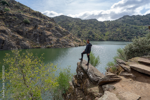 man with his back turned looking at a mountain landscape in the Douro region of Portugal. photo