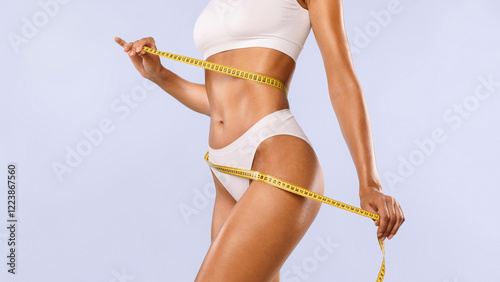Successful Weightloss And Dieting. Closeup Of Slim Lady Measuring Waist With Tape, Happy About Her Body Parameters, Standing Isolated Over Blue Studio Background. Slimming Concept. Banner