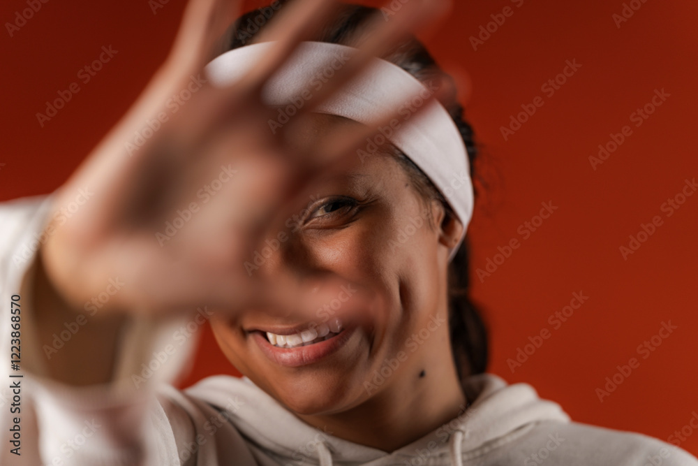 Photo of young brunette smiling with her hand towards the camera Photo of young brunette smiling with her hand towards the camera