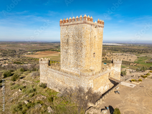 Aerial view of Nogales castle in Spain with homage tower, battlements and 4 circular towers on a hilltop photo