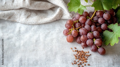 Obraz na płótnie Grape seeds scattered on a soft, natural surface with a few whole grapes beside them. w salonie