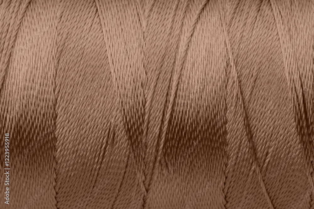 Sewing thread in mocha mousse shade, closeup. Trendy color of 2025 year Sewing thread in mocha mousse shade, closeup. Trendy color of 2025 year
