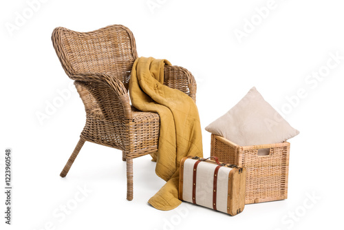 Wicker armchair with blanket, basket and suitcase isolated on white background photo