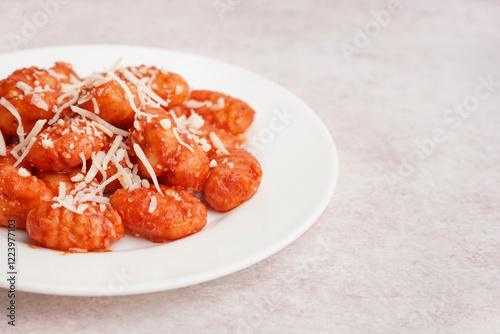 Plate of tasty gnocchi with cheese on white background photo