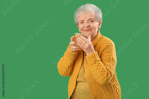 Senior woman with glass cup...