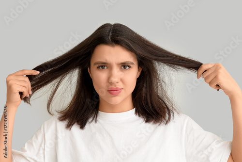 Young woman with dandruff problem on white background photo